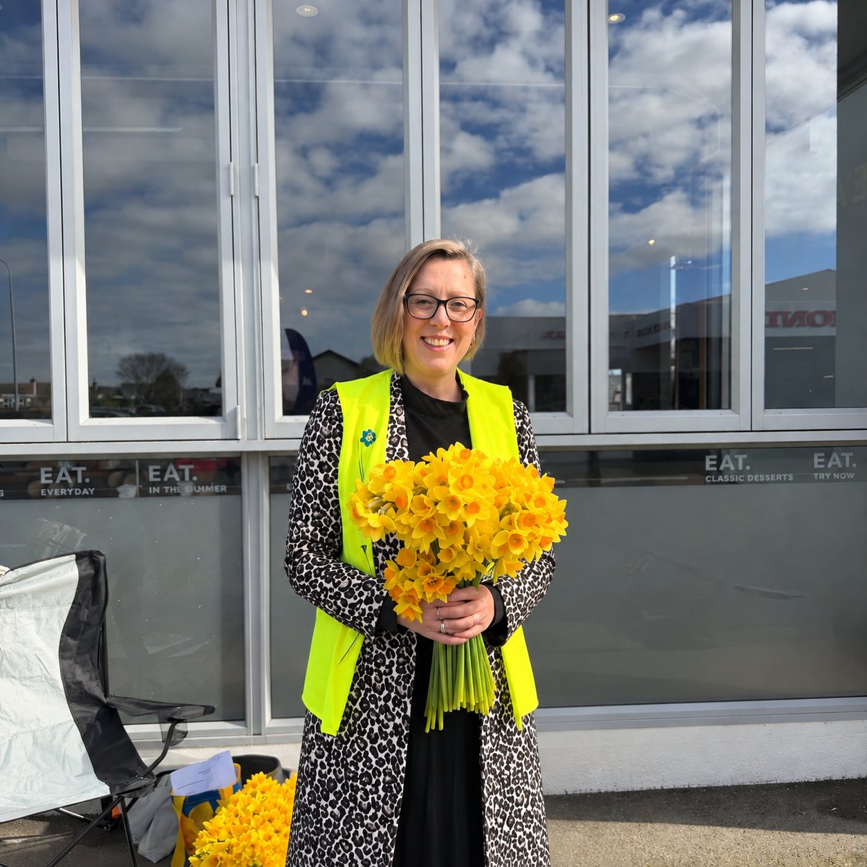 Michelle holding a bunch of daffodils for the Cancer Society's Daffodil Day